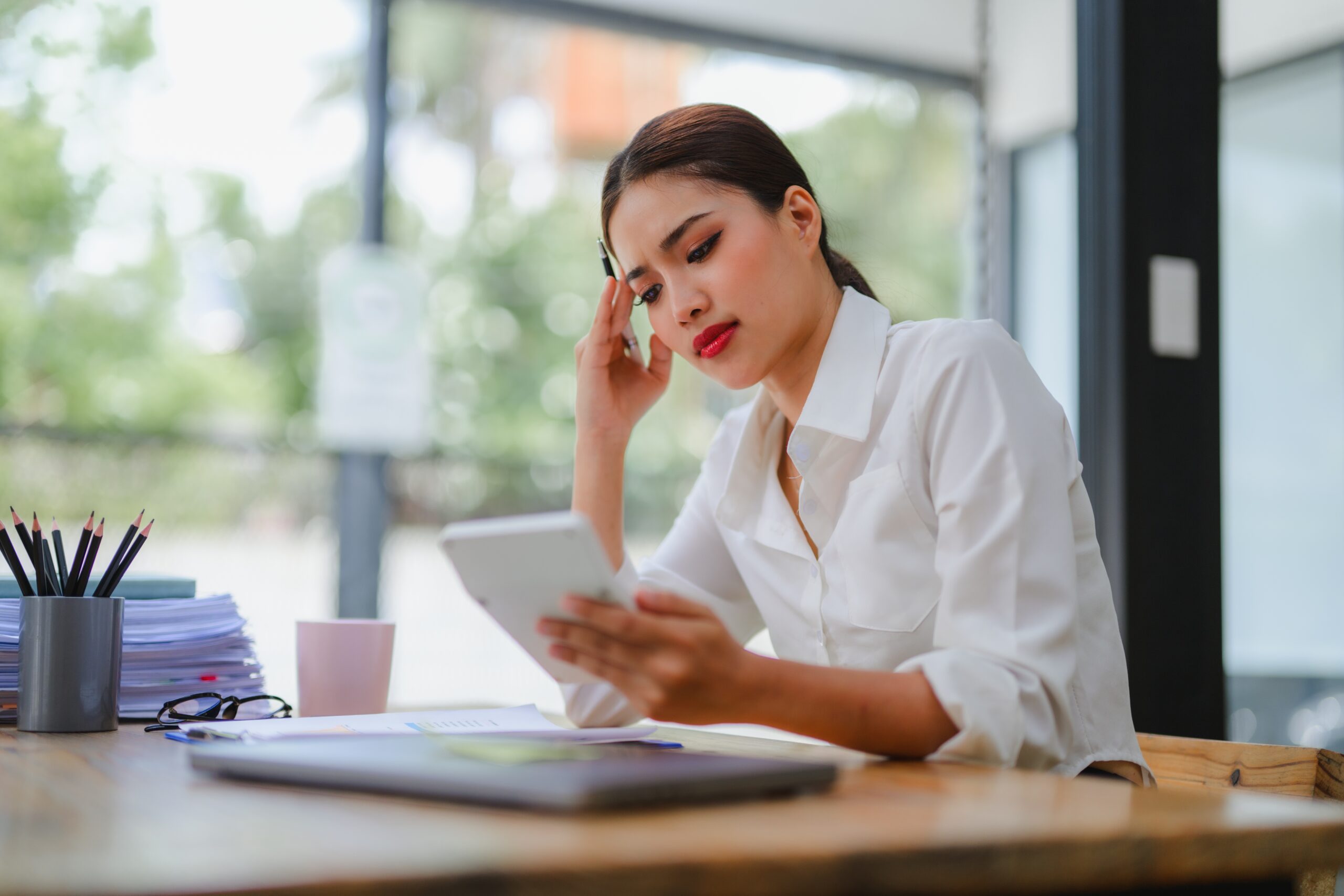 Woman at her desk overwhelmed with work.