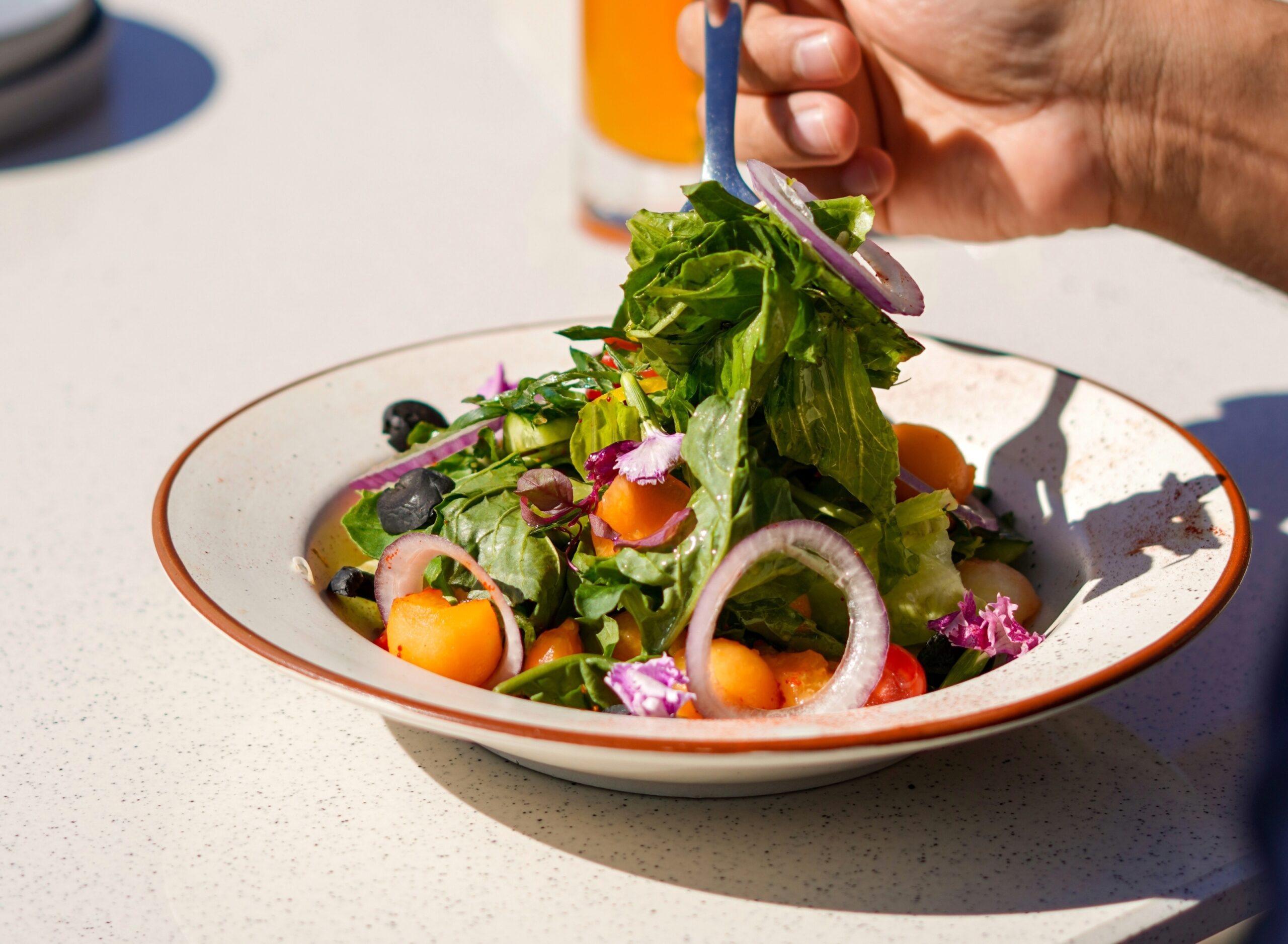 A man enjoying a green salad for lunch.