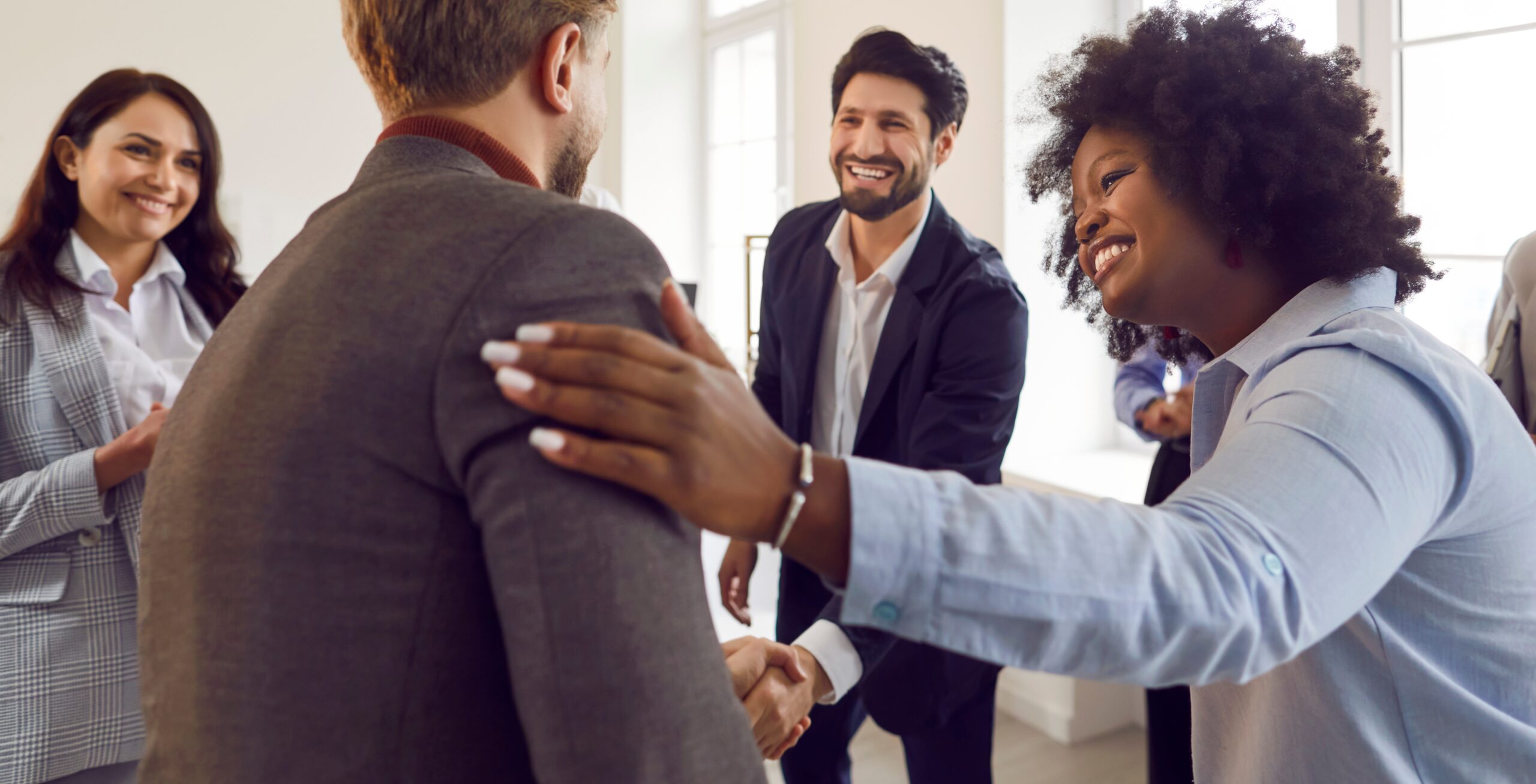A group of colleagues complimenting a coworker.