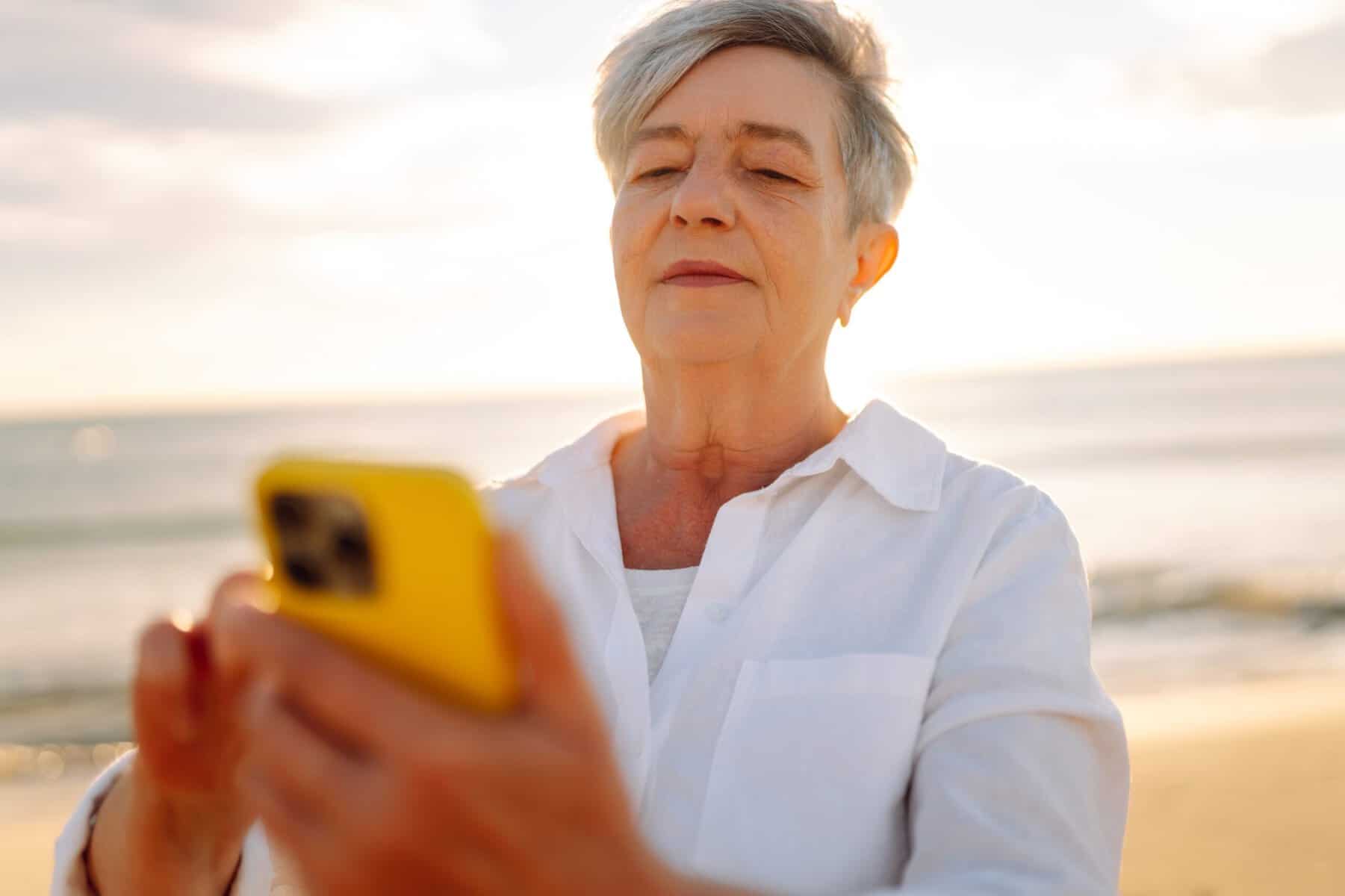 A senior woman using social media on her phone.