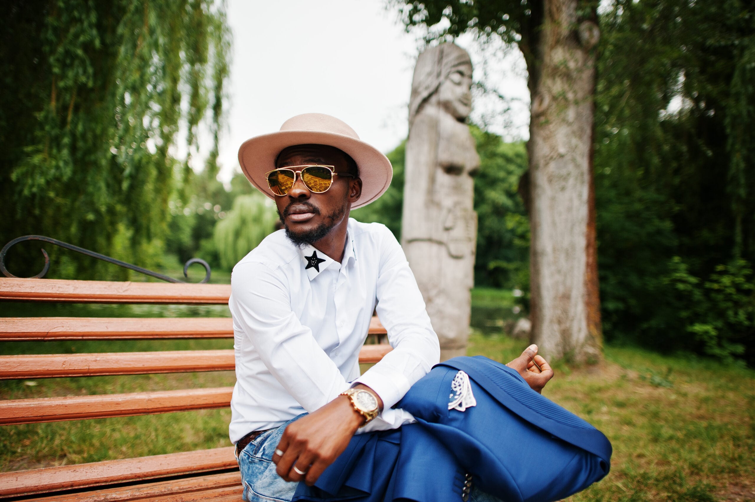 A well dressed gentleman enjoying a day at the park.
