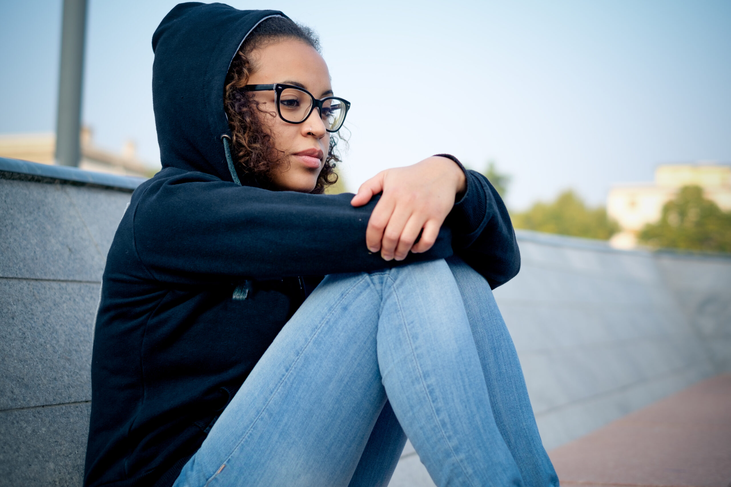 Woman sitting alone looking joyless.