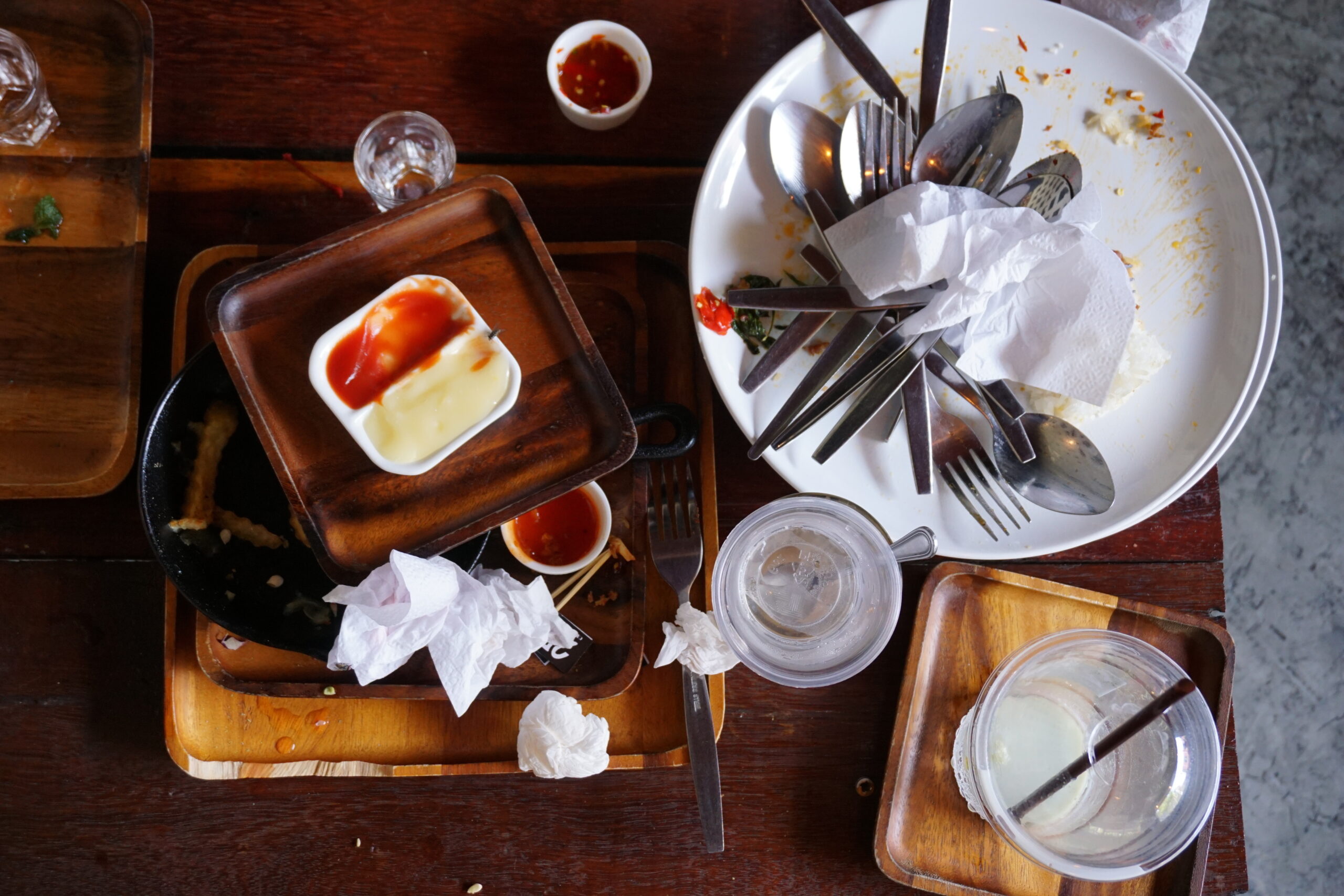 A messy table left behind in a food court.