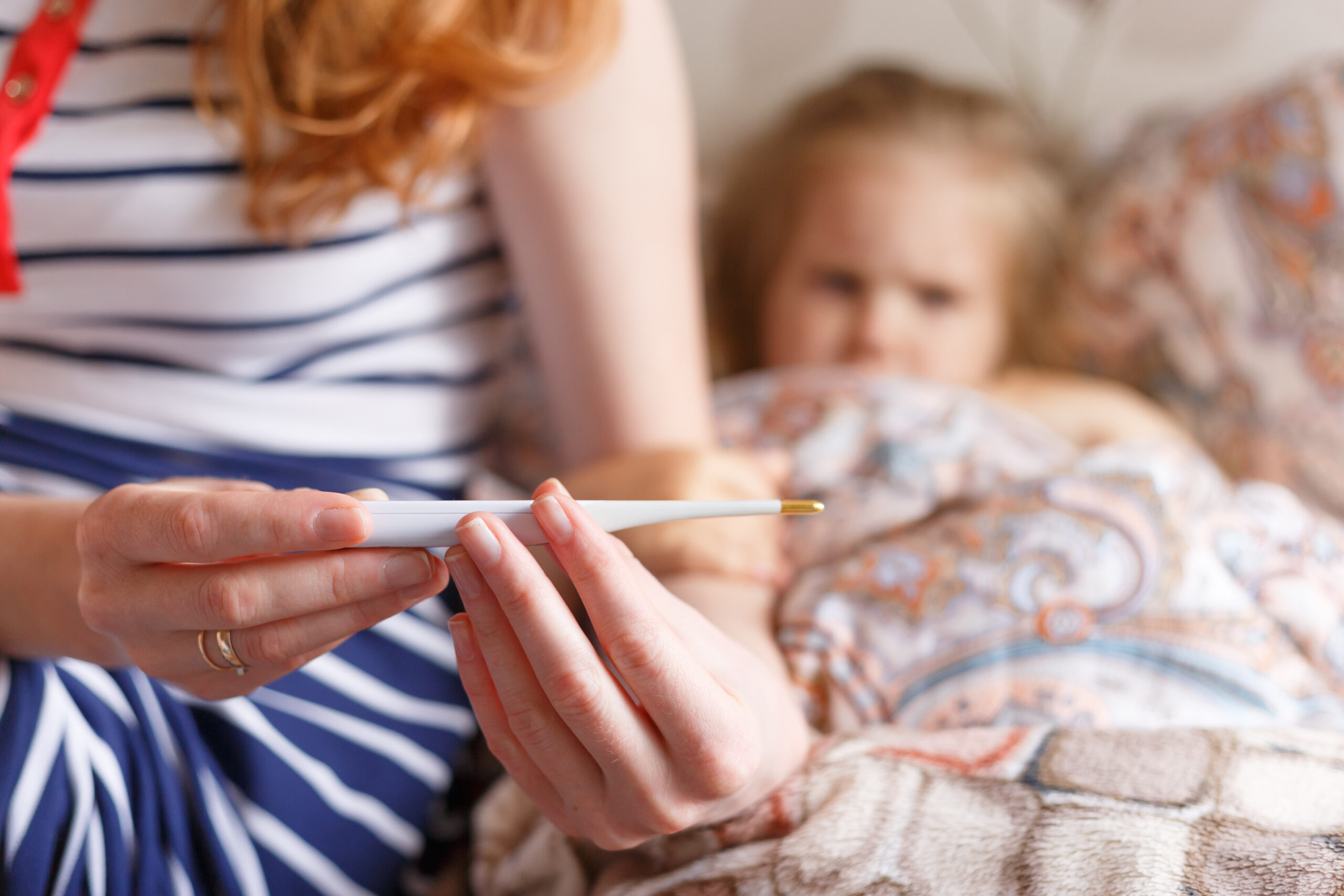 A mother taking care of her child sick with a fever.