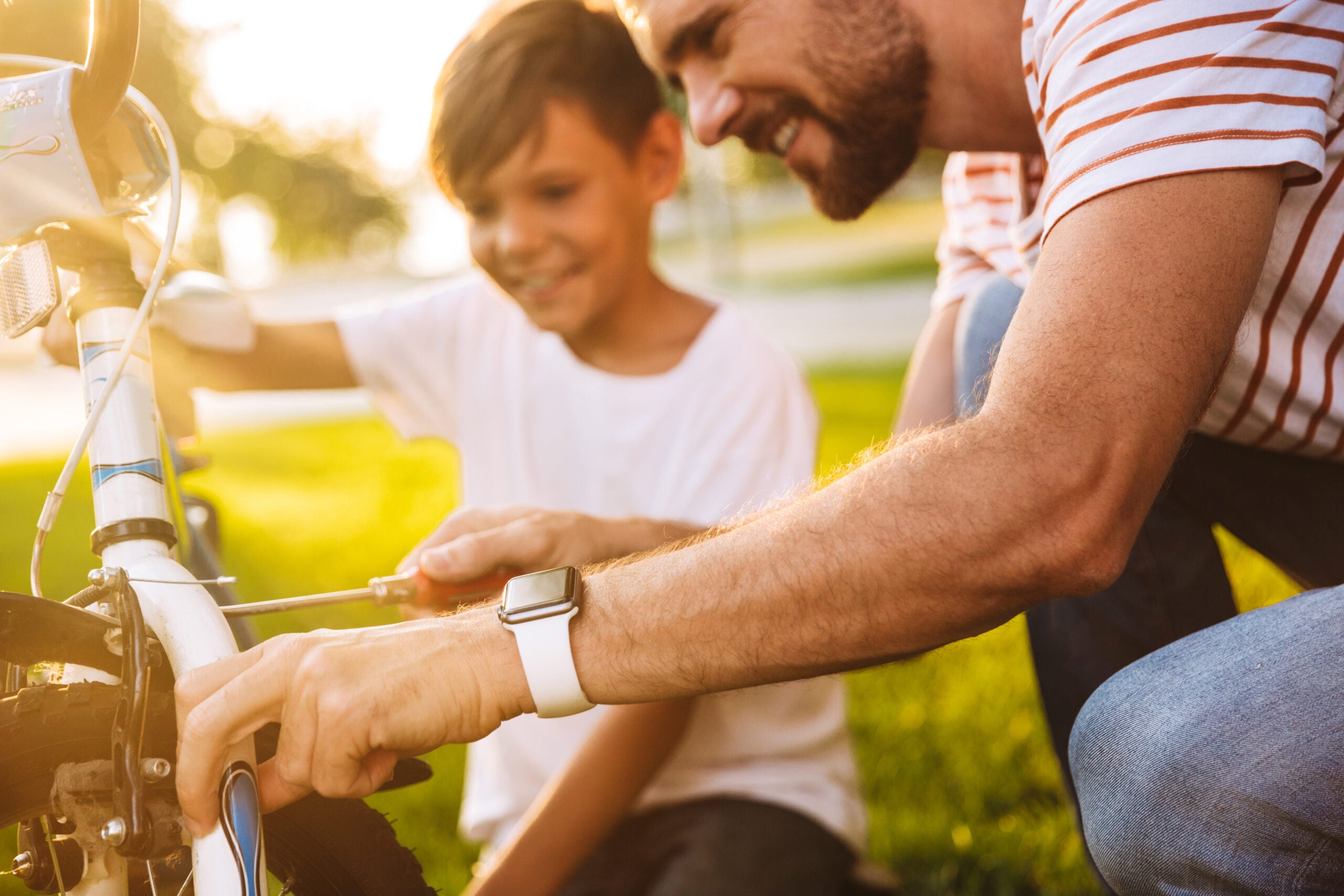 A father helping to fix his son's bicycle.