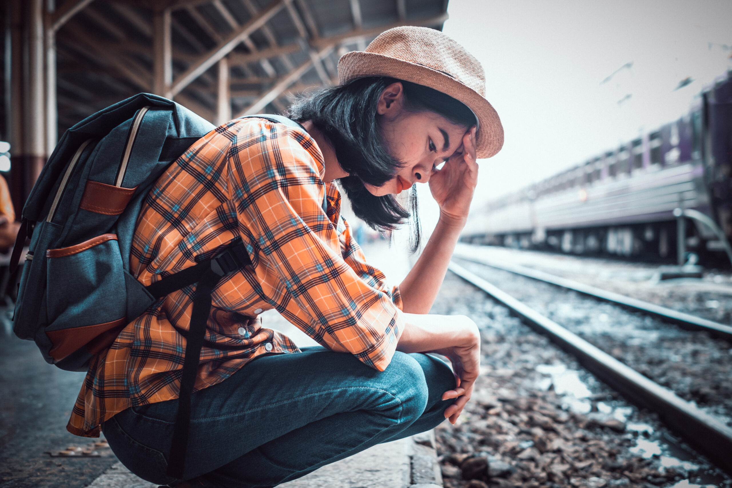 A woman feeling stressed that her train plans have changed.