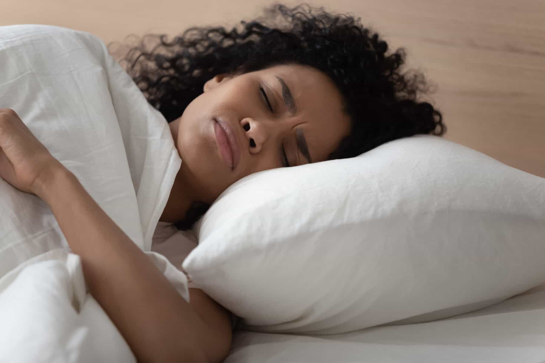 An exhausted woman unable to fall asleep.
