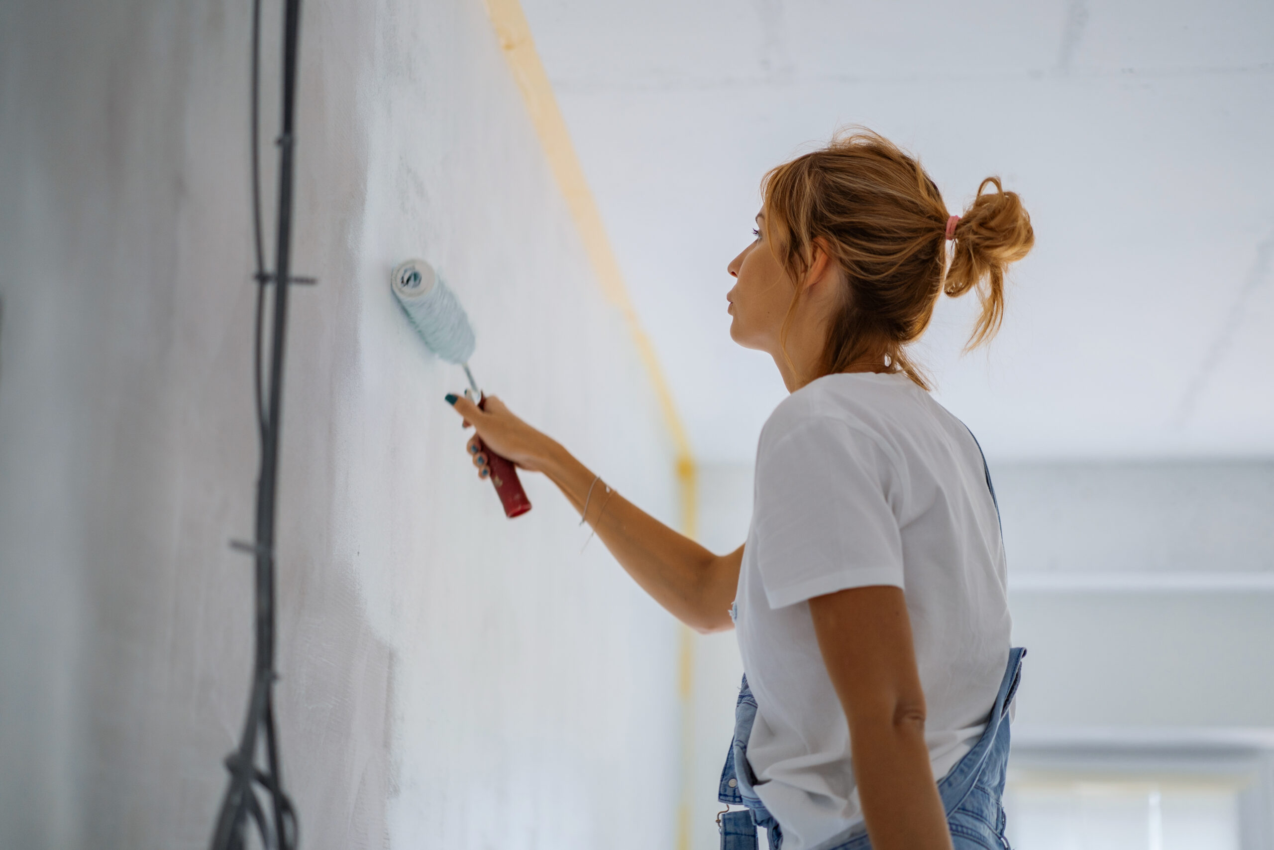 A woman making renovations to her home with painting.