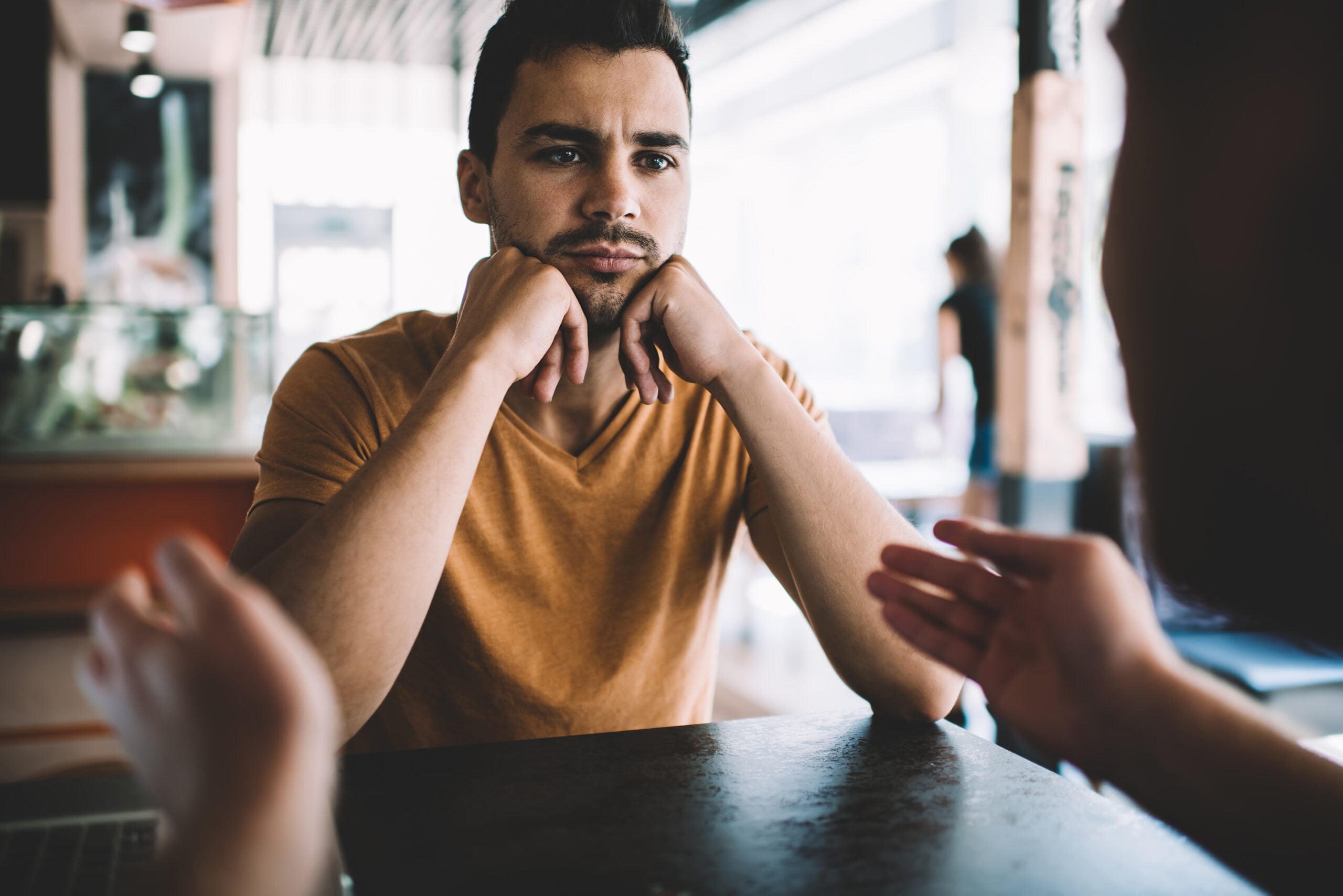 An introverted man feeling overwhelmed in conversation.