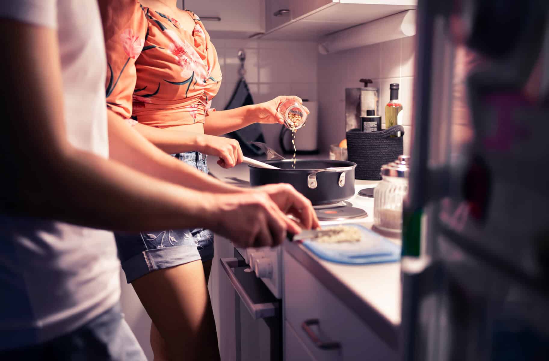 A young couple cooking dinner together at home.