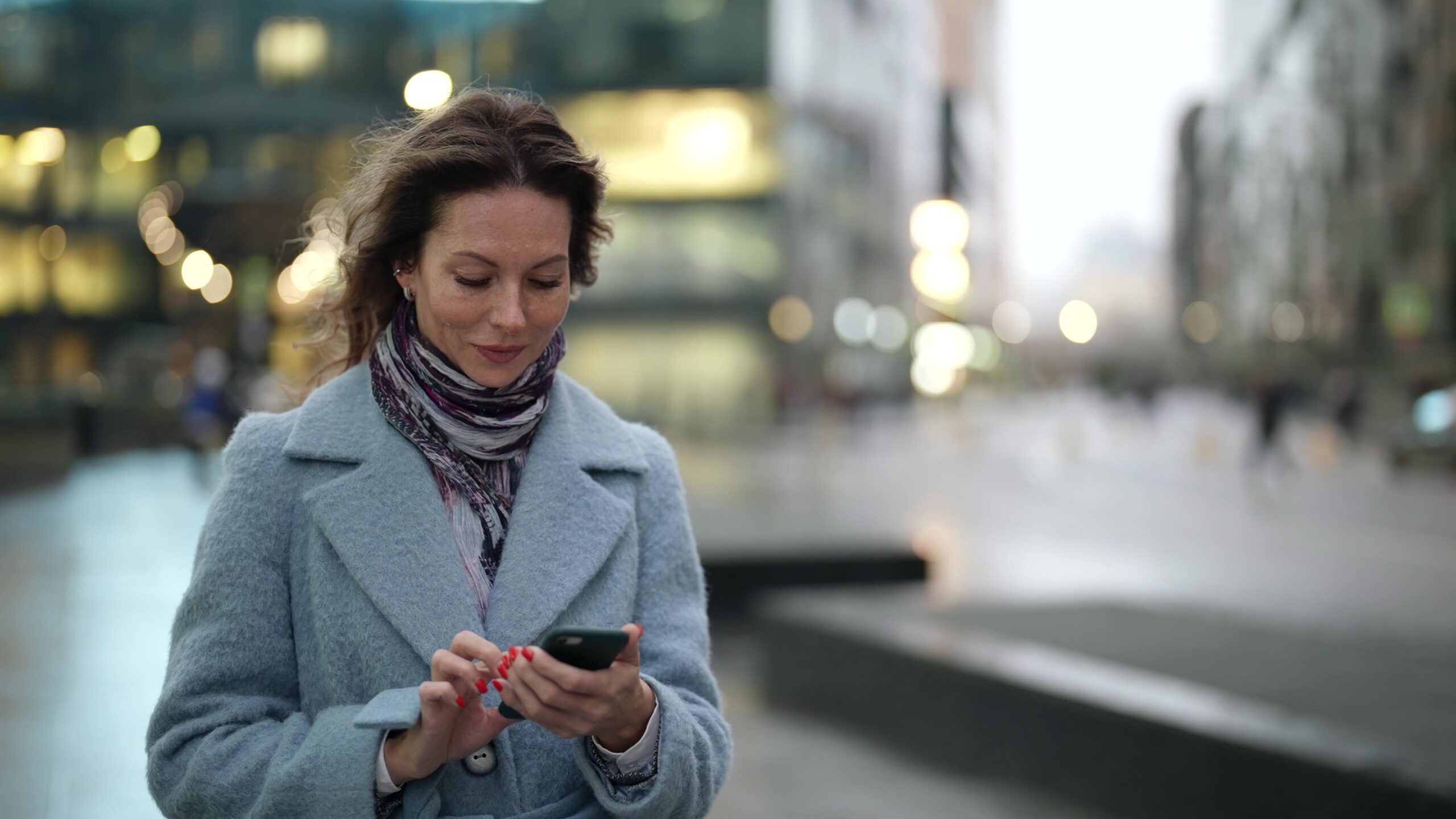 Confident woman standing outside on her phone.