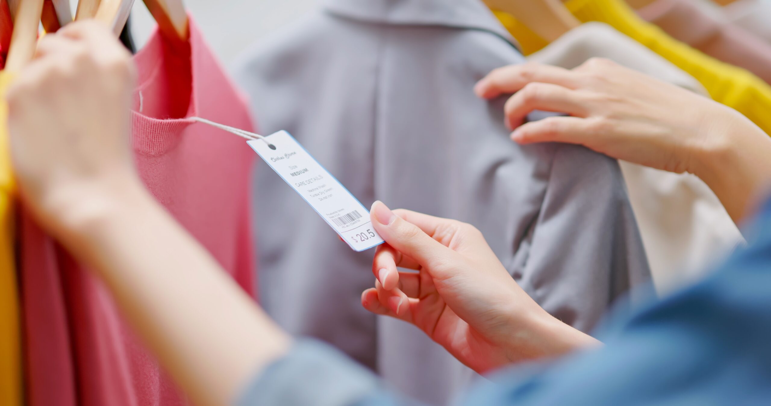 A woman checking the price tag of a jacket.