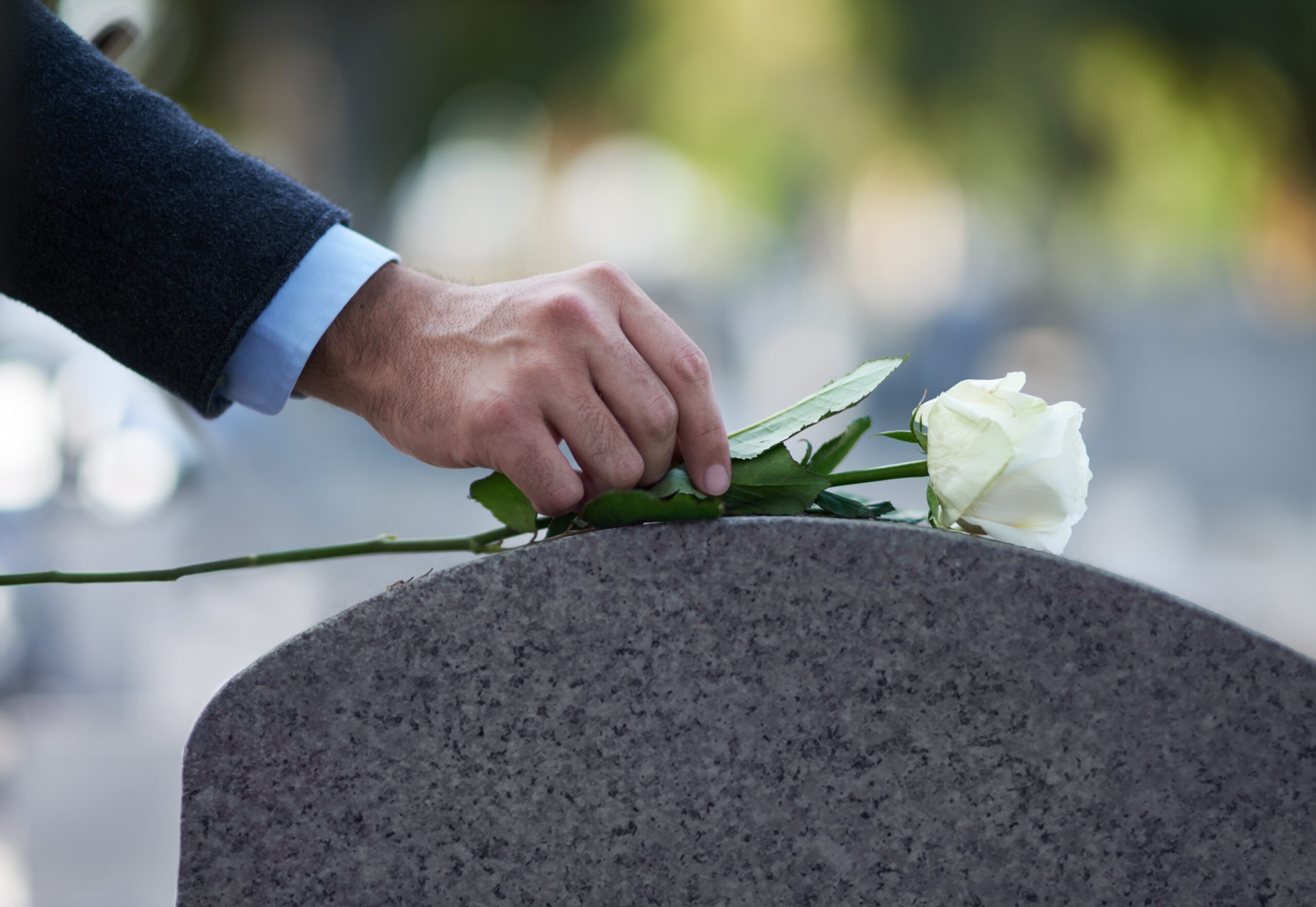 A son paying his respects to his parent's grave.
