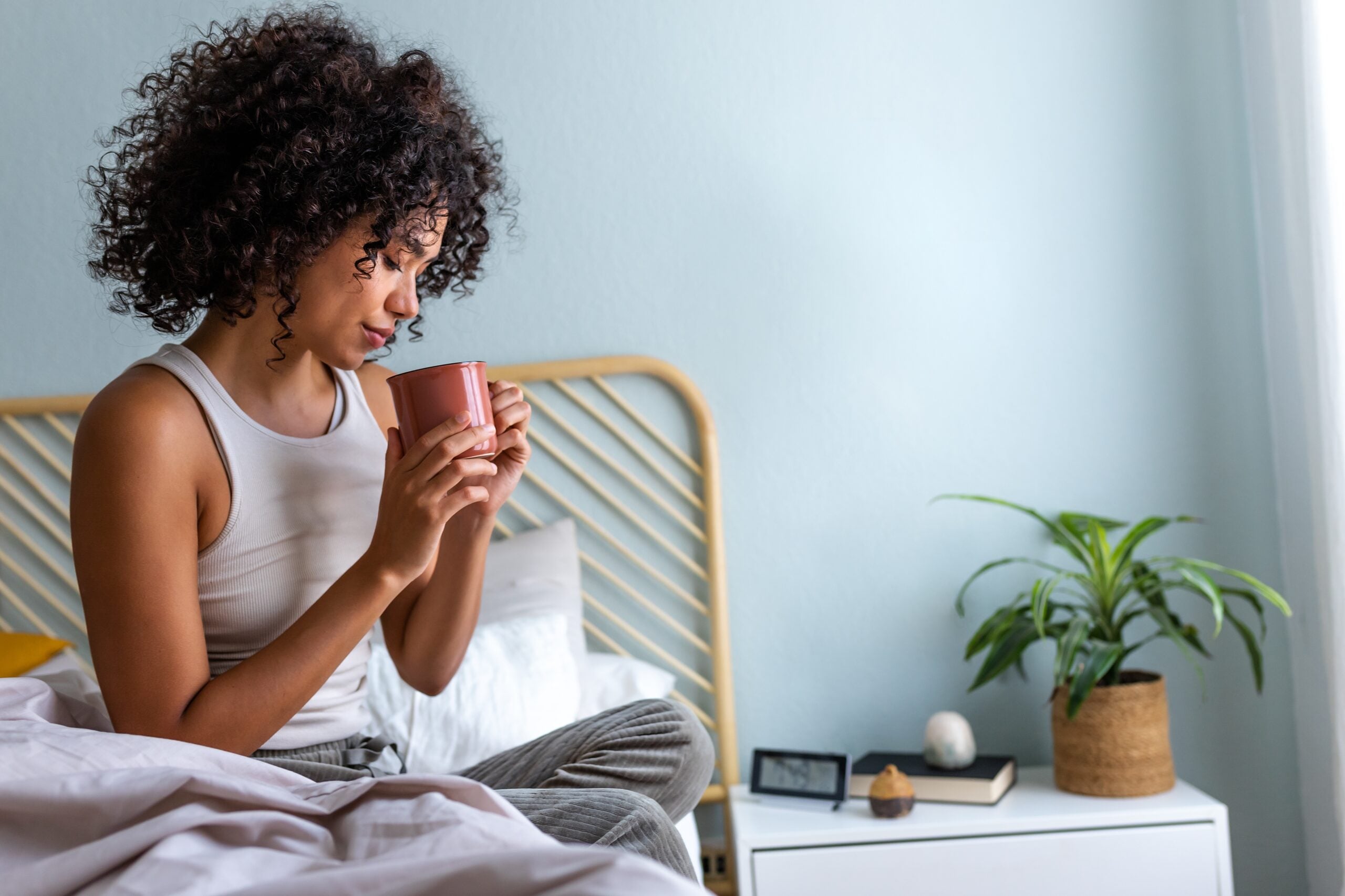 An independent woman having morning coffee in bed.