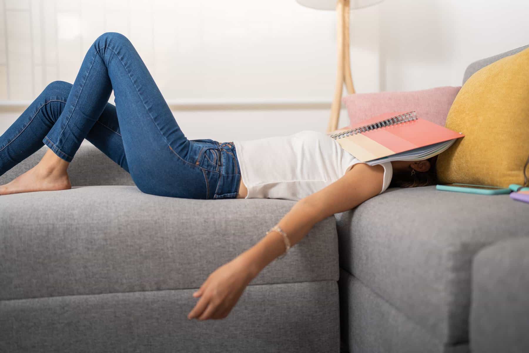 An exhausted woman feeling lazy on the couch.
