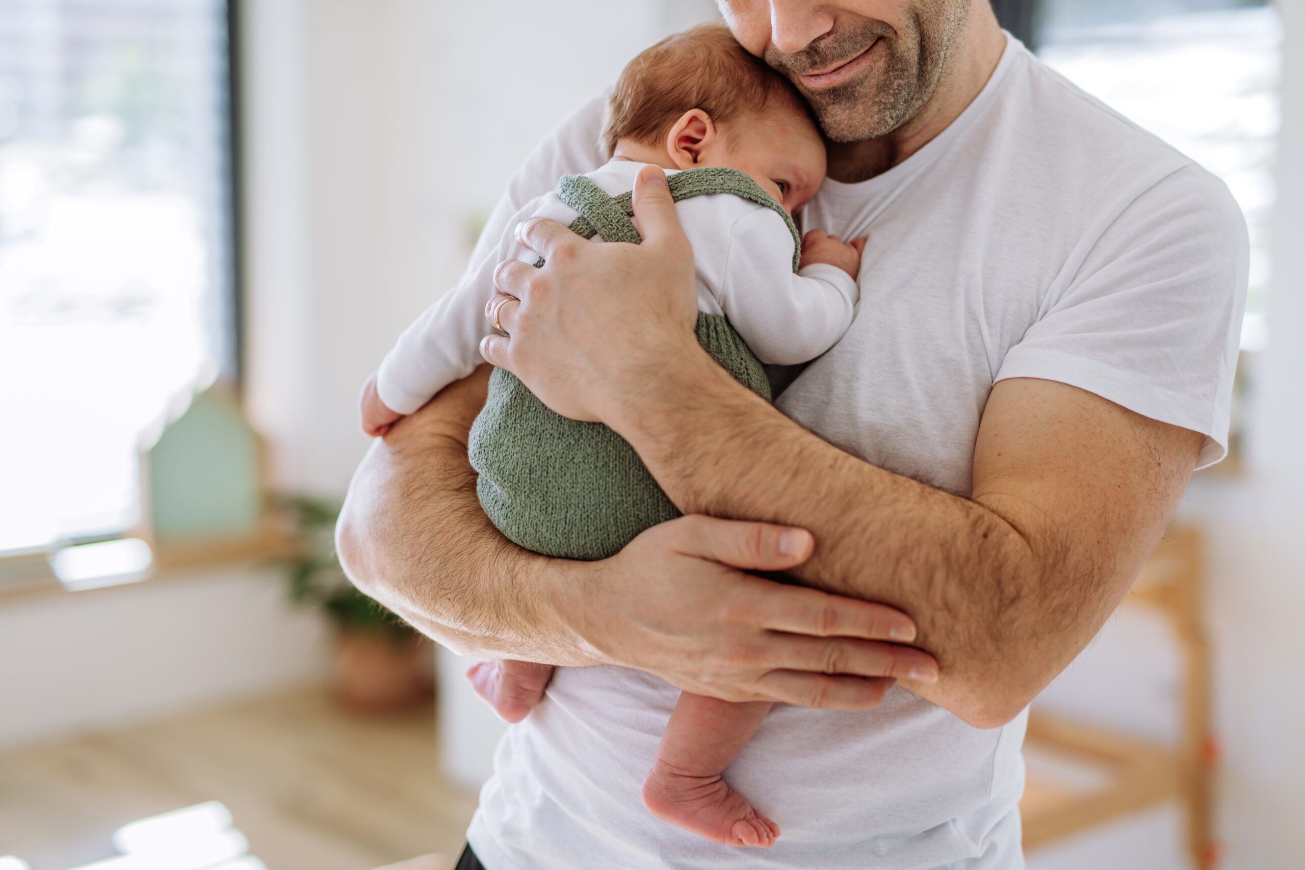 A solid father holding onto his little baby.