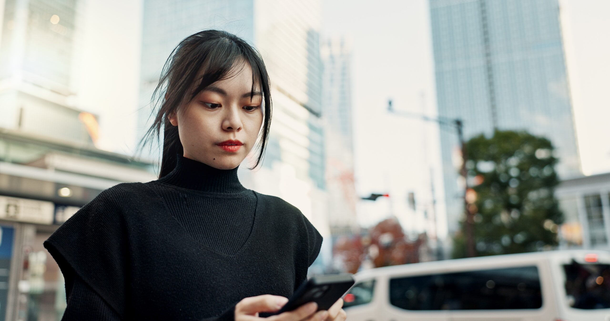 A woman deciding not to take a call while on a walk outdoors.