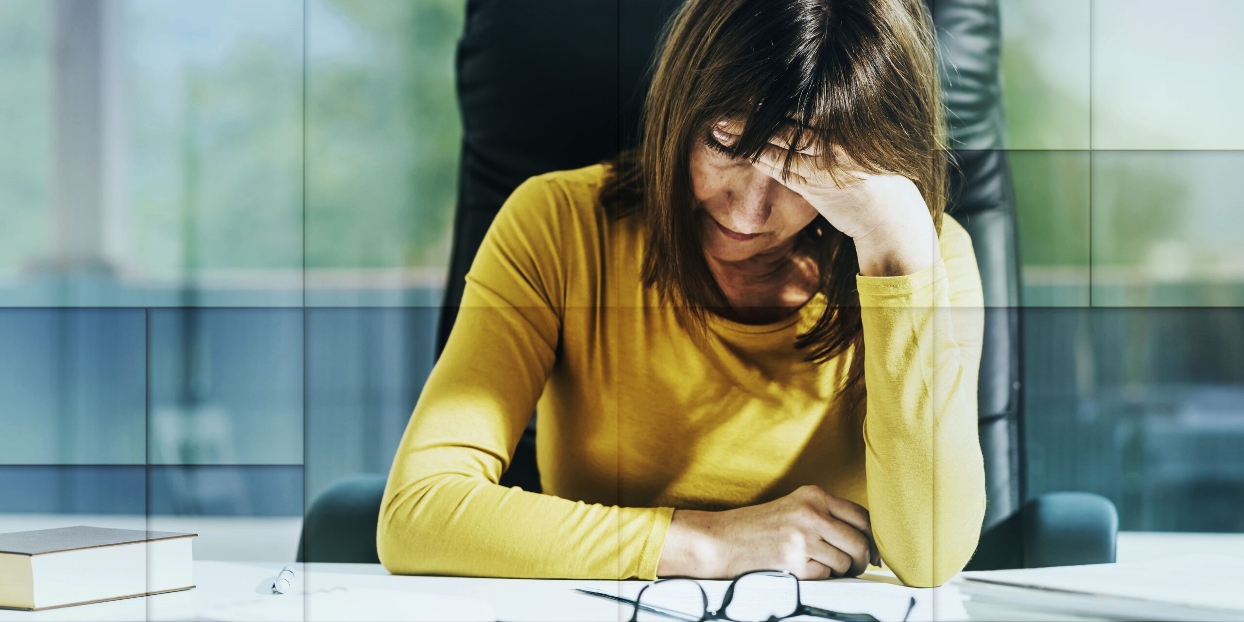 Woman sitting at desk looking tired and unfulfilled.