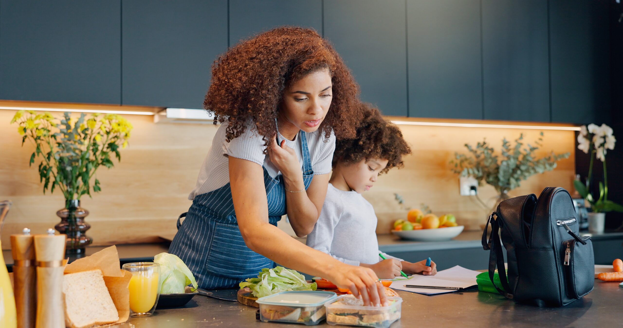 A woman multitasking with her son at home.