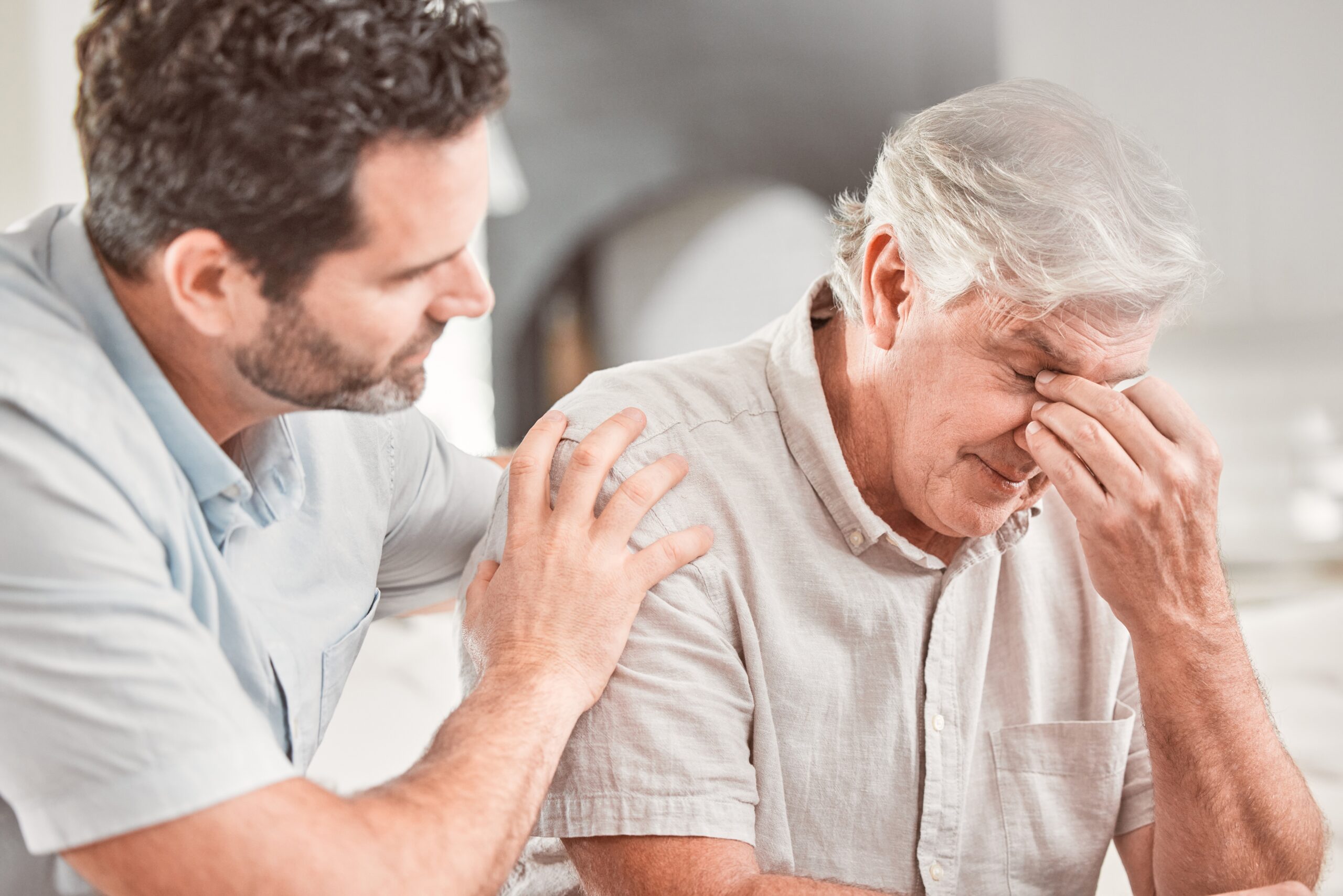 A senior father letting his adult son know he's not feeling well.