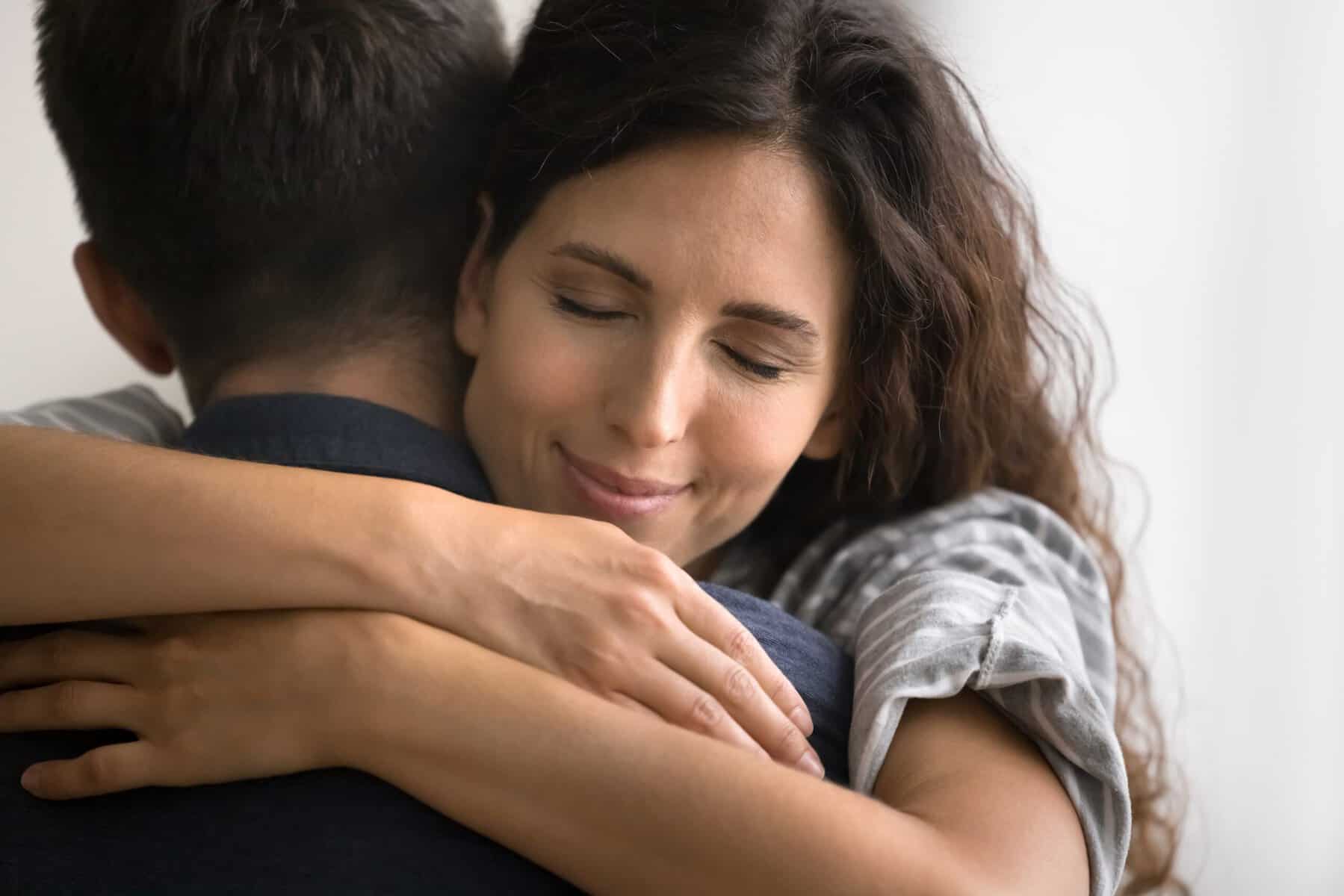 A woman hugging her husband giving him support.