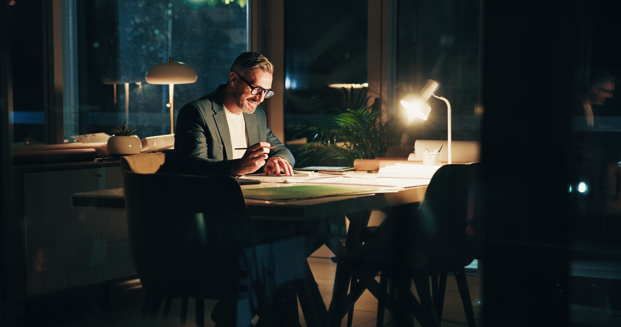 A man working at his desk at night.