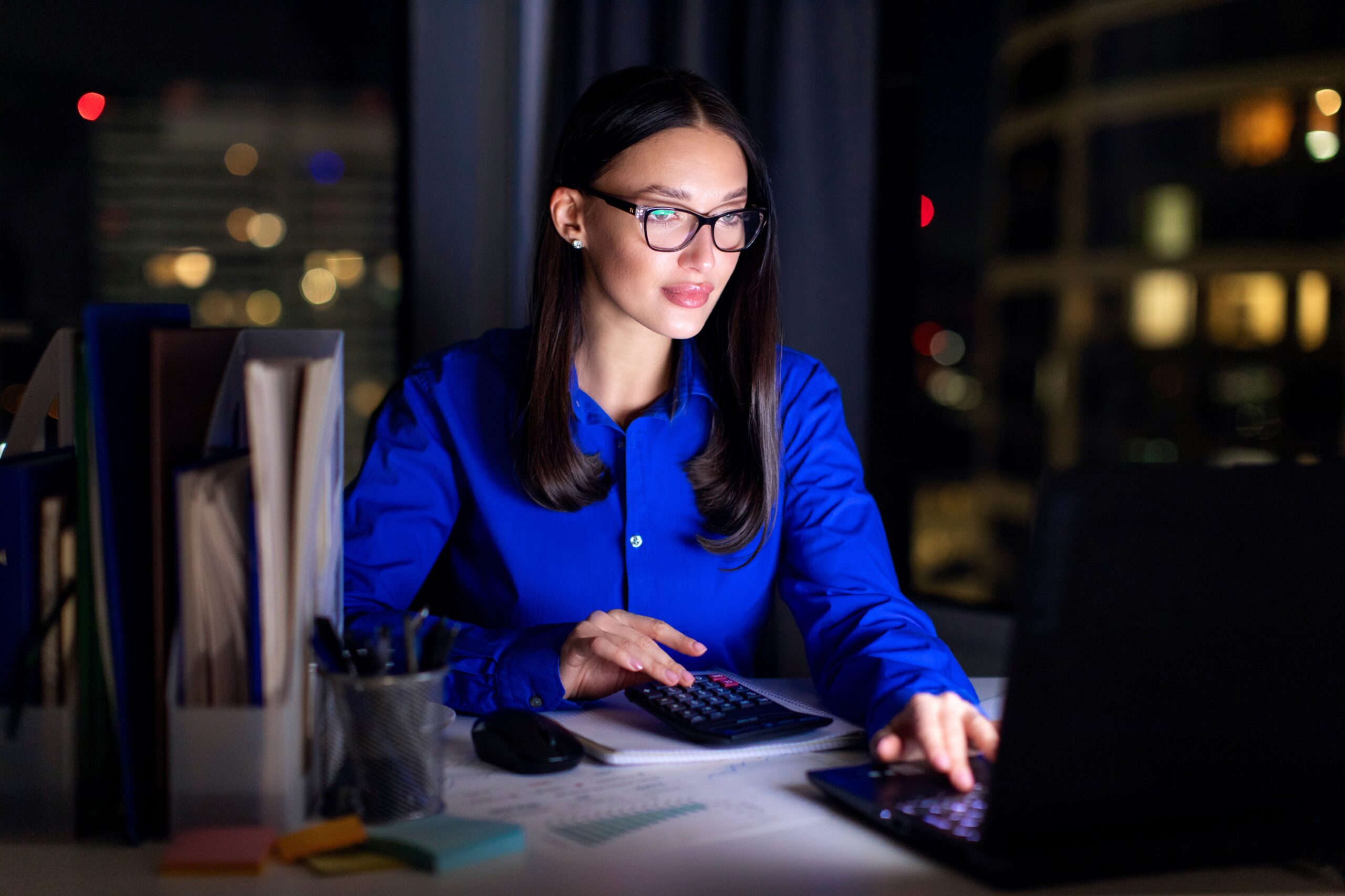 A woman working at her desk at night.