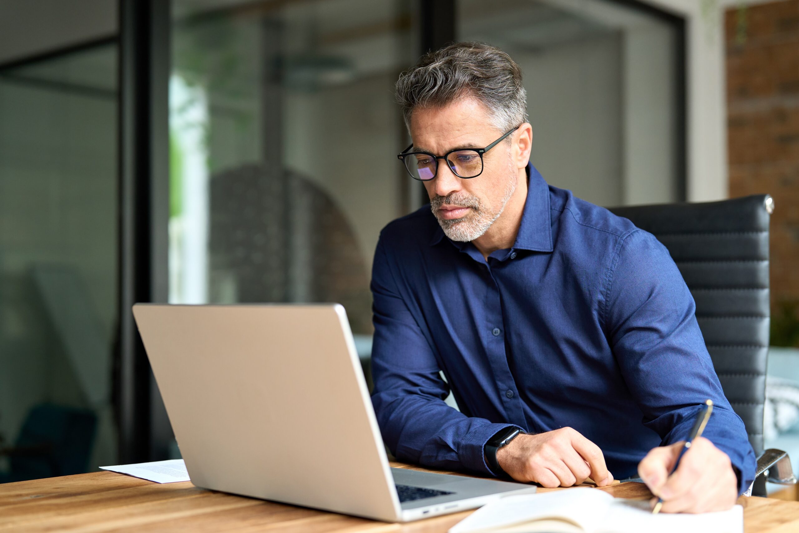 A kind and successful man at his computer at work.