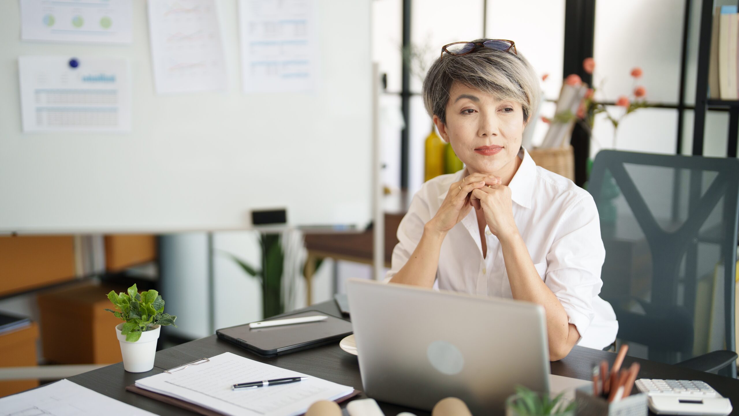 A middle aged woman at her desk at work.