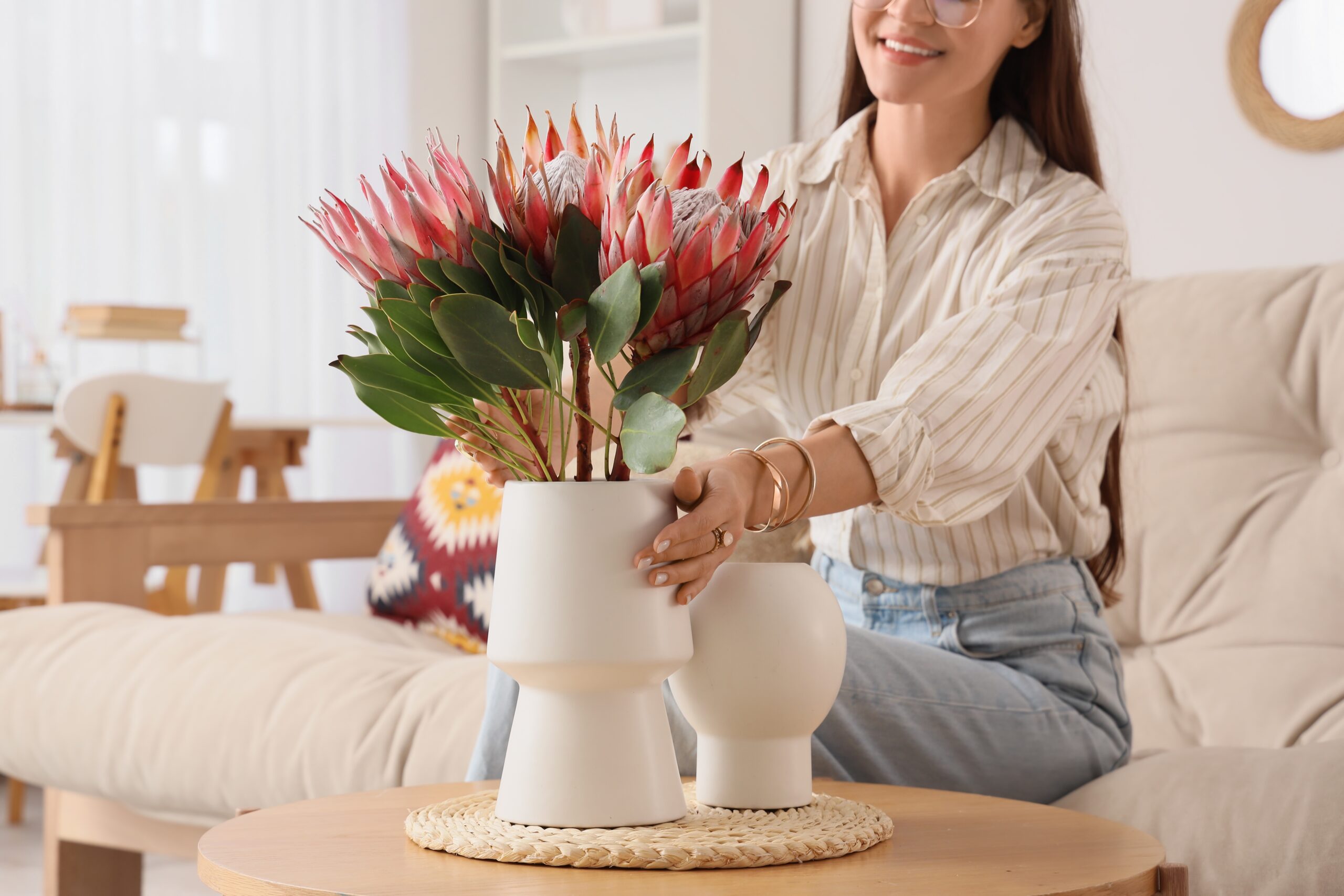 A woman arranging beautiful flowers in her living room.