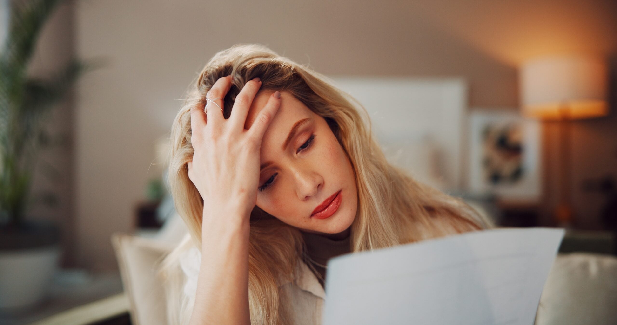 A stressed woman paying her bills at home alone.