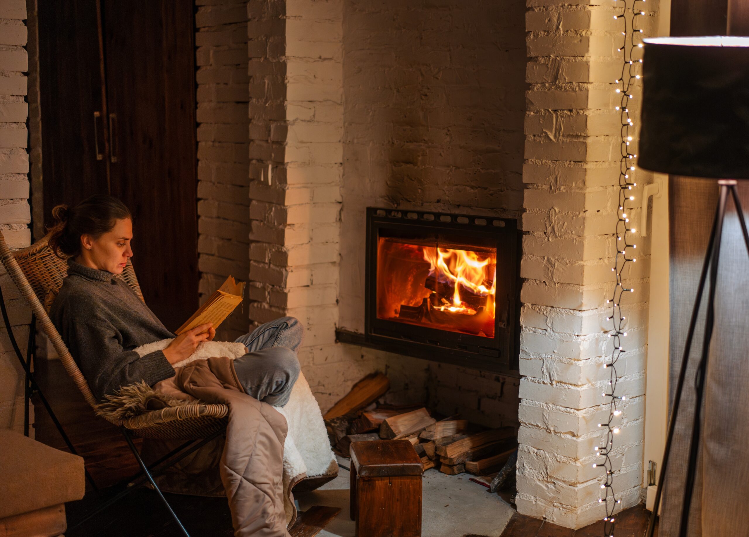 A woman spending time alone by a fire.
