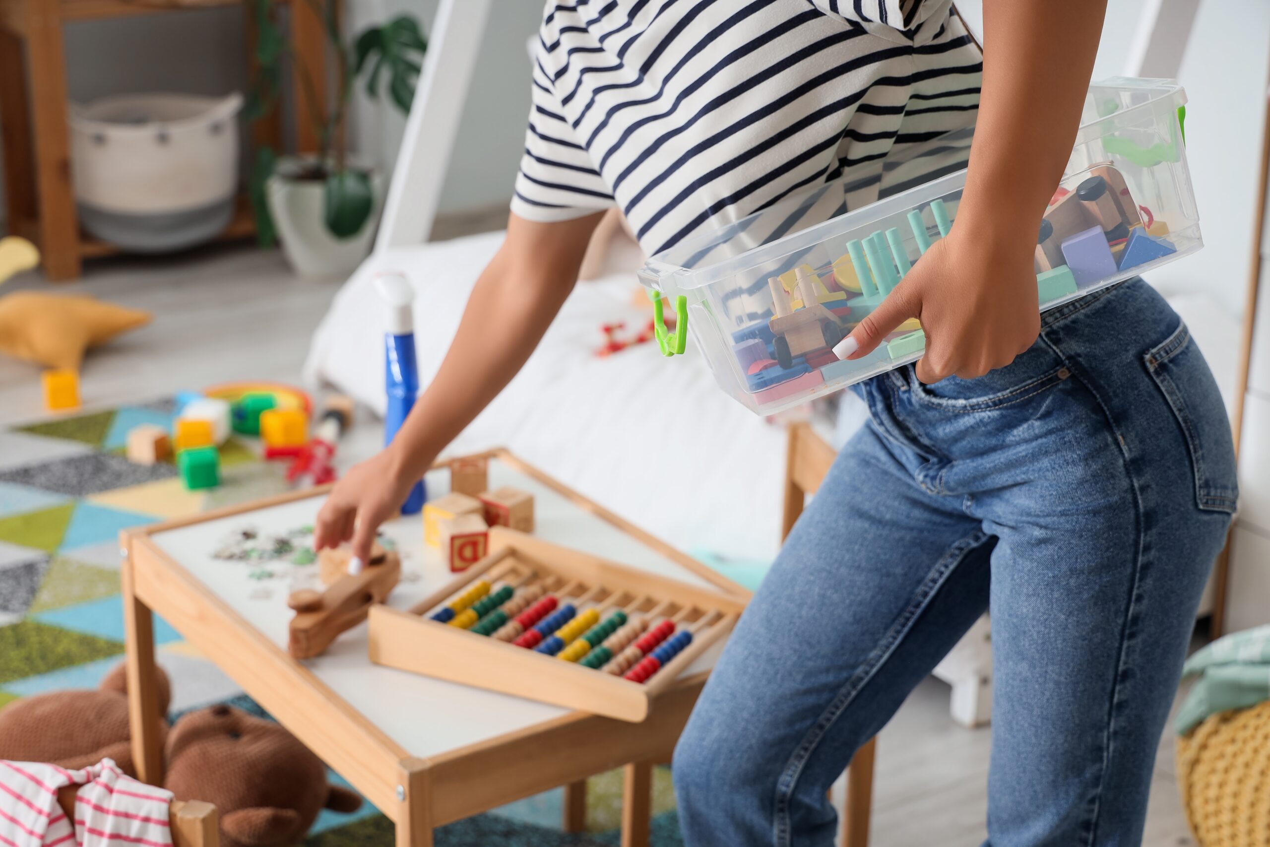 A busy mother cleaning up her children's playroom.