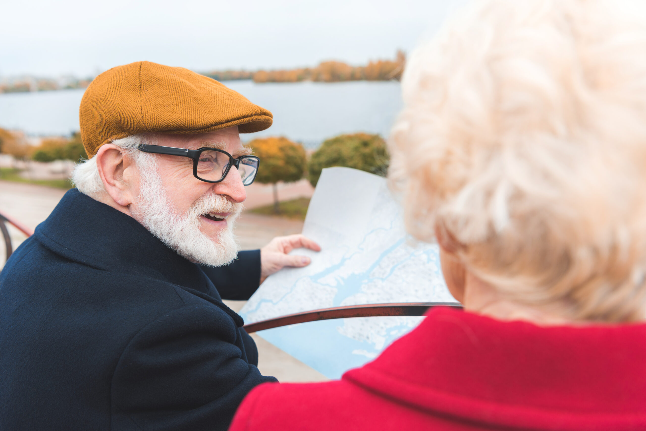 A senior couple using a map to walk around a new city.