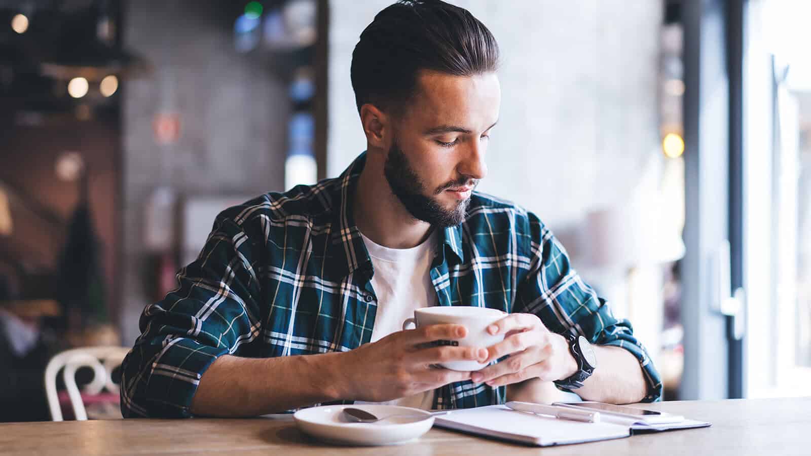 Man journaling at a coffee shop.