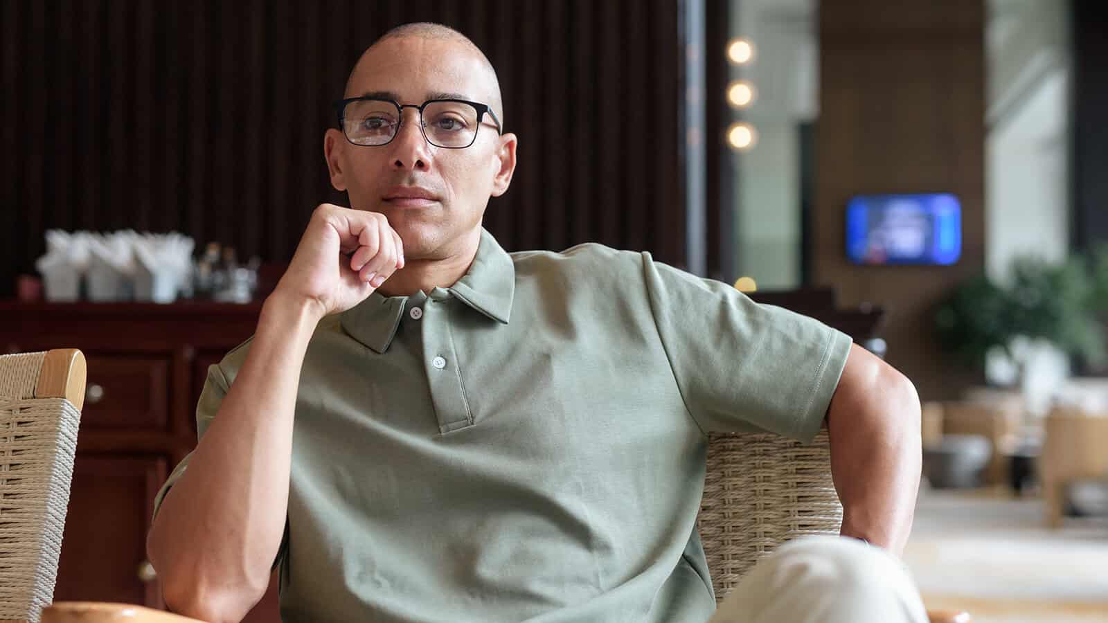 man in his 40s posing in hotel cafe or bar pondering life