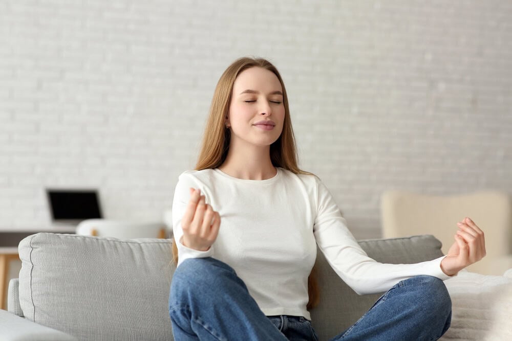 Young woman meditating on a couch