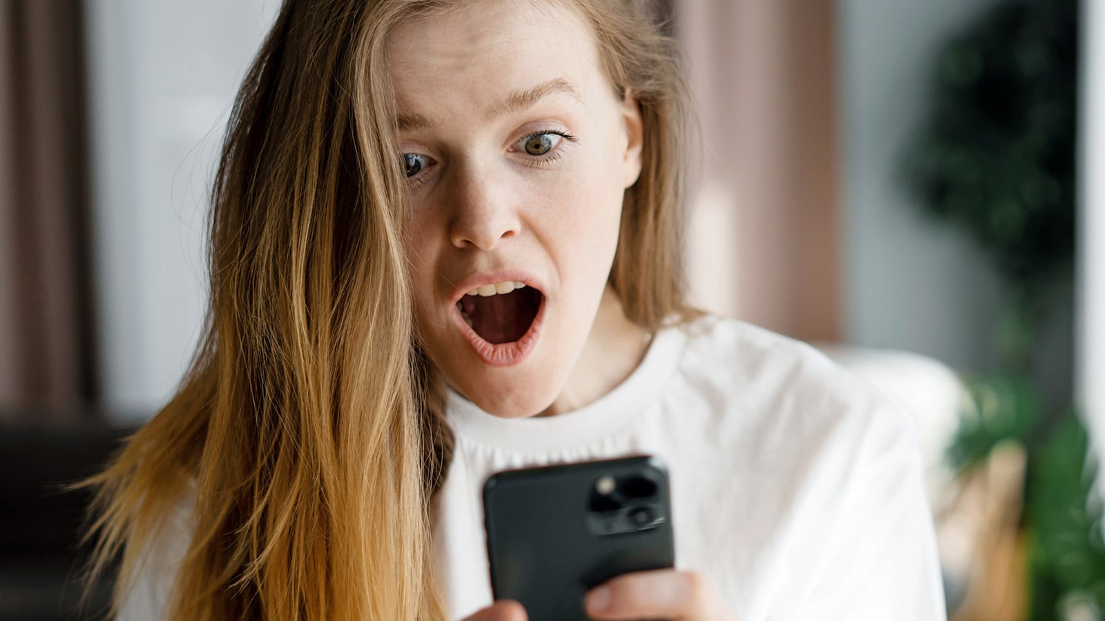 Surprised woman looking at her cell phone
