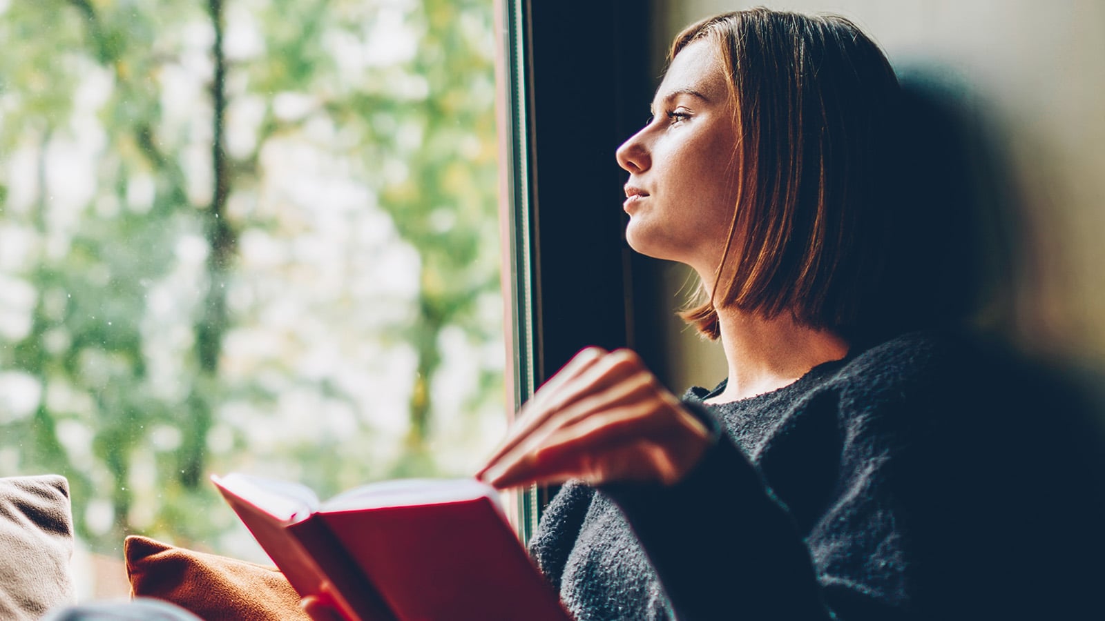 A woman reading a well-worn favorite book on the couch.
