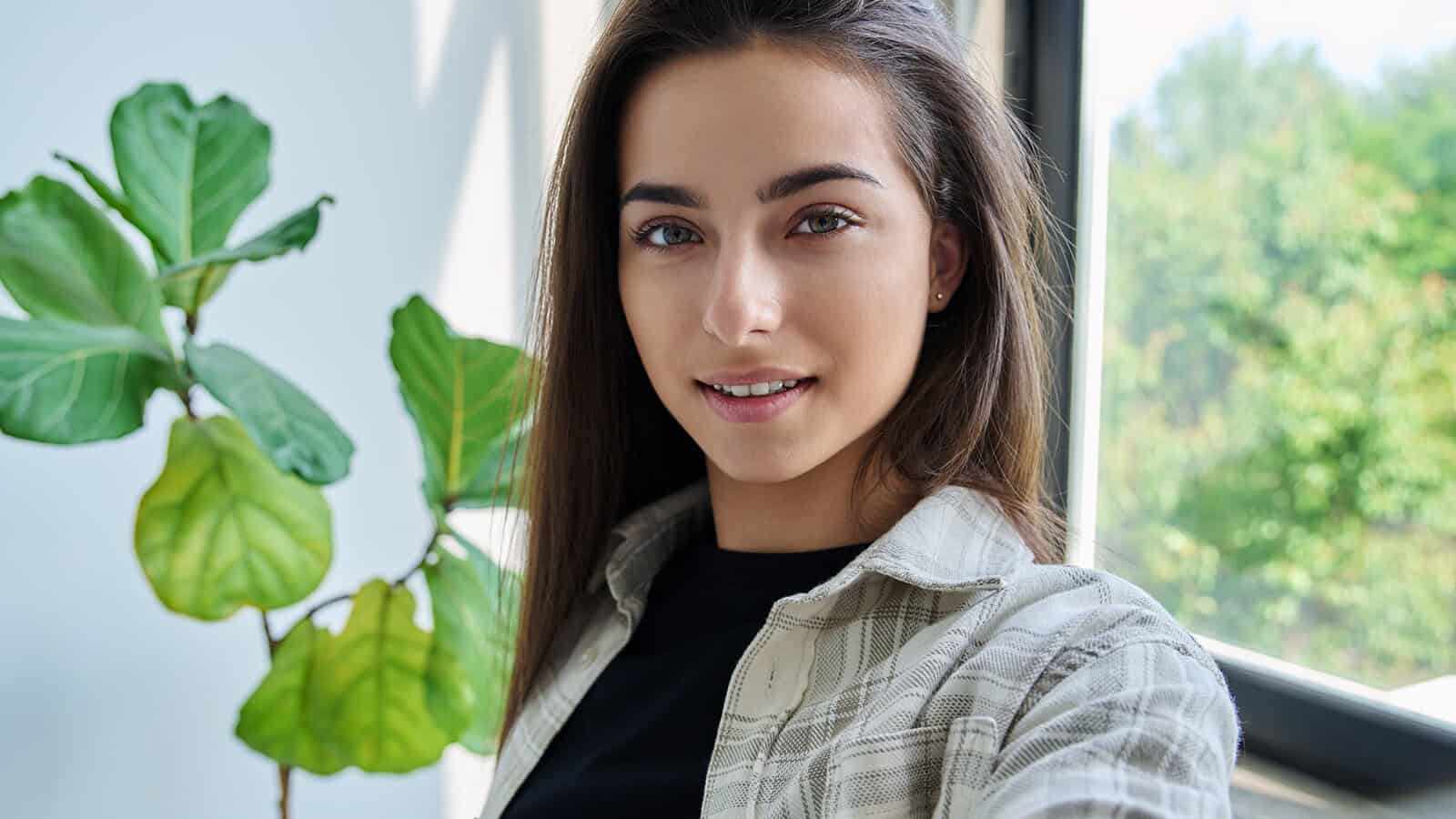 A young woman with long brown hair smiling at the camera.