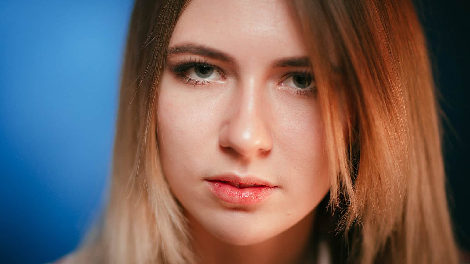 Close-up portrait of a young woman with a neutral expression.