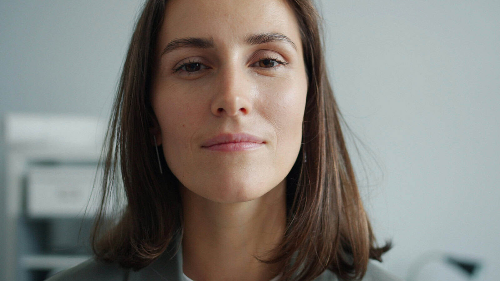 A close-up portrait of a woman looking directly at the camera.