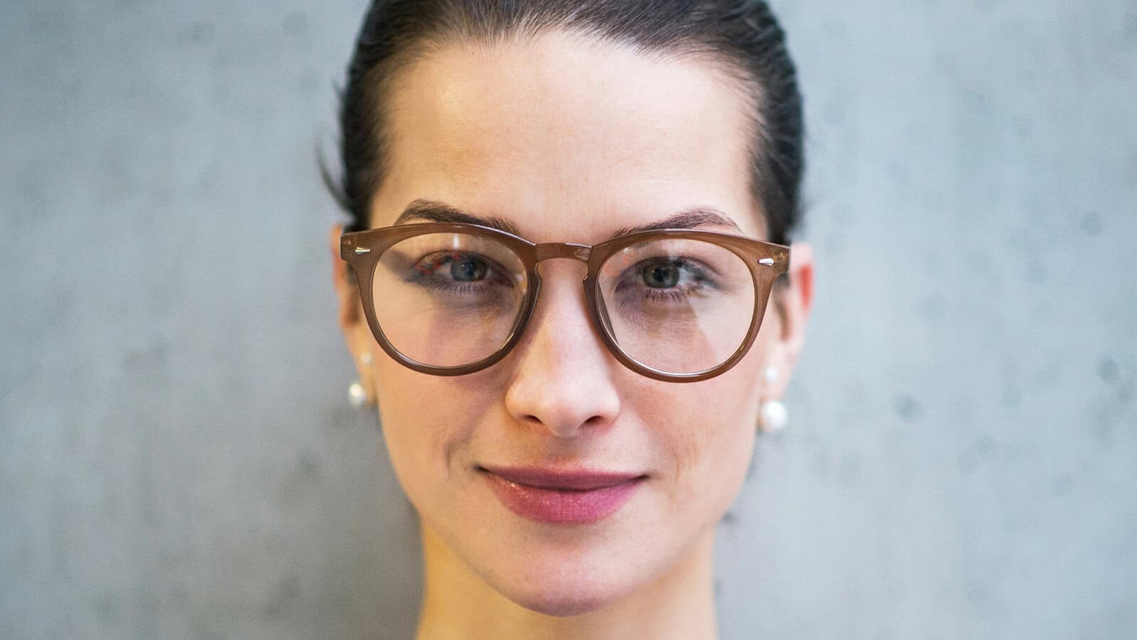 A woman wearing brown-framed glasses.