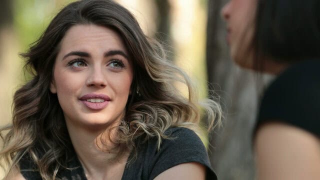A woman looking at someone off-camera while engaged in conversation.