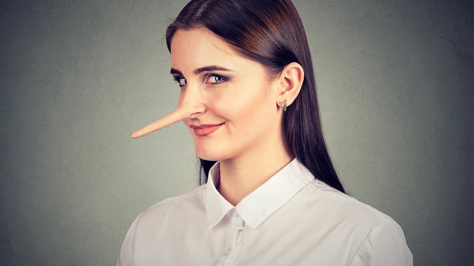 A woman with a long, wooden Pinocchio-style nose looking sideways with a smirk, illustrating the psychology of lying.