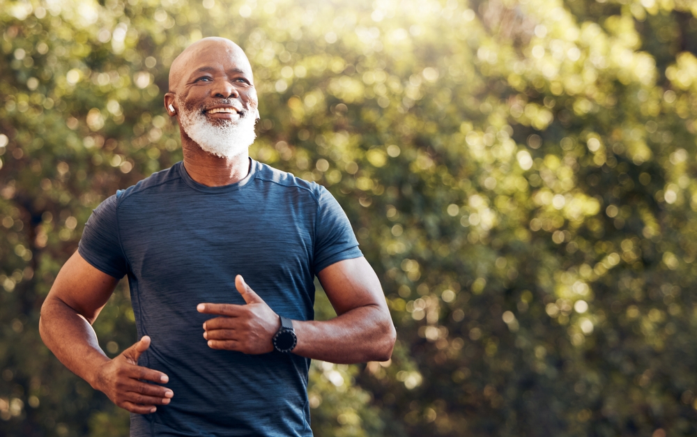 Man listening to music whole he runs outdoors.