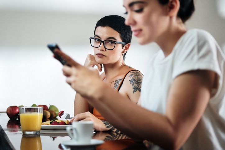 Jealous Woman Looking at her friend on her phone