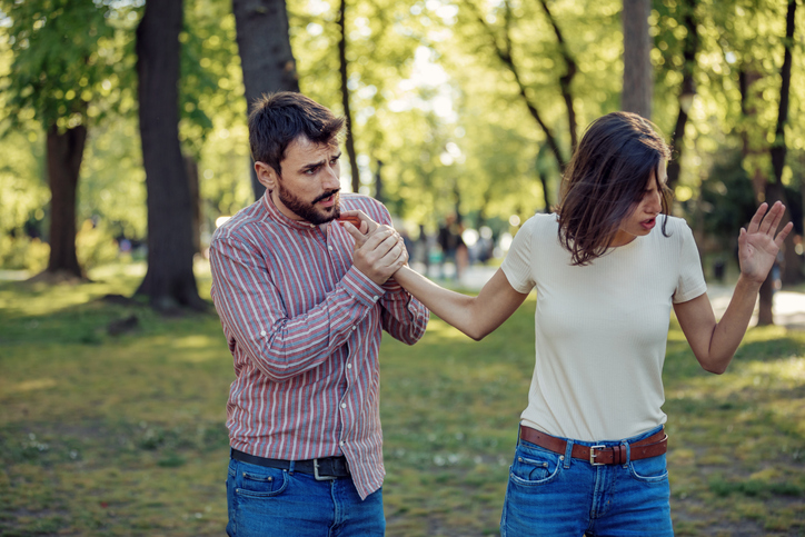 Handsome Young Man and His Beautiful Girlfriend are Having a Serious Debate Outdoors in the Public Park. Couple in Relationship is Going Through the Serious Problems and Difficulties. They are Yelling at Each Other.