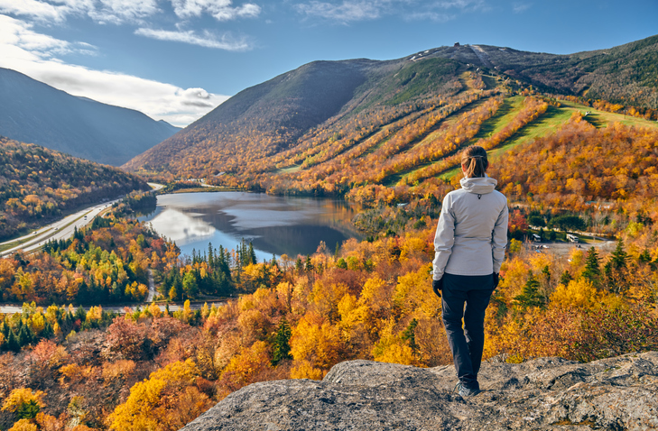 Woman hiking at Artist's Bluff, New Hampshire in autumn.
