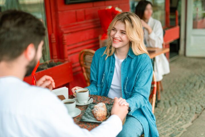Young couple sitting at a table in an outdoor cafe.